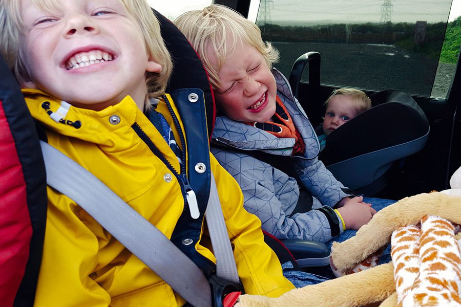 Auto Insurance - Kids Smiling and Laughing while Sitting in Car
